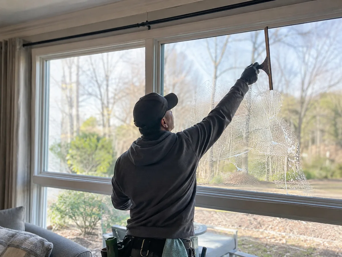 Squeegeeing an interior picture window in a Berkeley County SC home